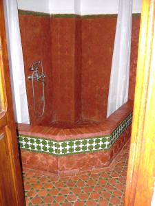 a shower in a bathroom with a tile floor at Casa La Palma in Chefchaouene