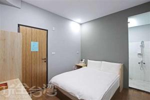 um quarto com uma cama branca e um chuveiro em Ark stay方舟文旅山嵐新館溜滑梯商務民宿 em Jiji