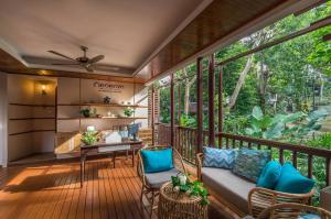 a screened in porch with a desk and chairs at Pakasai Resort - SHA Extra plus in Ao Nang Beach