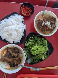 une table avec trois assiettes de denrées alimentaires et de riz dans l'établissement Chamisland Hanhly homestay, à Hội An