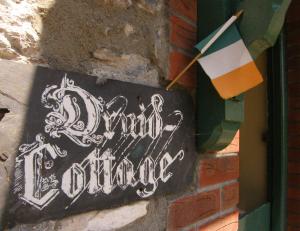 Ein Schild an einer Ziegelmauer mit einem Schild, auf dem langsames Tanzen steht. in der Unterkunft Druid Cottage in Kenmare