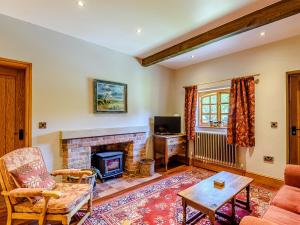 a living room with a fireplace and a tv at Barn End in Lincoln