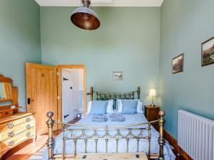 a bedroom with a bed with blue walls at Barn End in Lincoln