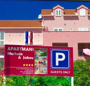una señal de aparcamiento frente a un edificio rosa en Luxury Apartments Marhella & Jakov, en Makarska