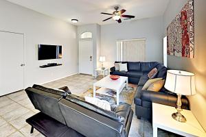 uma sala de estar com um sofá e uma televisão em Sawgrass Summer em Cathedral City