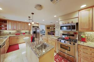 een grote keuken met roestvrijstalen apparatuur en houten kasten bij Calle Quito Escape Permit# 217,228 in La Quinta