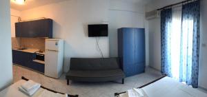 a kitchen with a couch and a blue cabinet at KARAOYLI apartments studios in Kokkino Nero