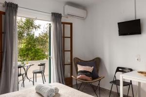 a room with a bed and a balcony with a table at Marias Seaside Apartments in Acharavi