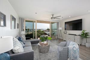 een woonkamer met een bank en stoelen en een tv bij Bayside Walk Escape Unit A in San Diego