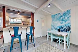 Beach Haven في سانتا كروز: مطبخ وغرفة طعام مع كراسي زرقاء وطاولة