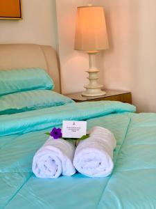 zwei Handtücher und ein Schild auf dem Bett in der Unterkunft SEA LA VIE @ LAGUNA CONDO RESORT in Port Dickson