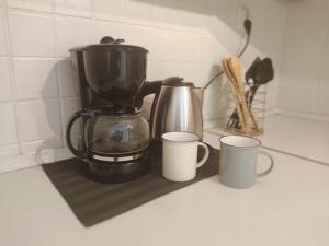 a coffee maker and two cups on a counter at Apartmani Danica in Risika