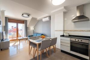 cocina y sala de estar con mesa y sillas en MA Maisons & Apartments Portonovo, en Portonovo
