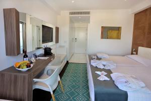 a hotel room with a bed with a desk and a sink at Nestor Hotel in Ayia Napa