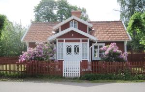 a small house with a fence and flowers at Bolmen in Bolmen