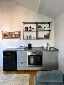 a kitchen with a stove and a sink at Galerie Apartment Self-Check-In in Kolbermoor