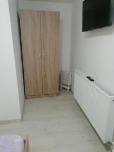 a white room with a cabinet and a television at Emyra's holiday rooms in Constanţa