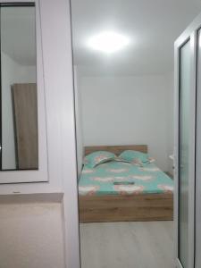 a small bedroom with a bed and a mirror at Emyra's holiday rooms in Constanţa
