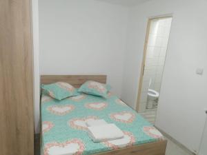 a bedroom with a bed and a mirror at Emyra's holiday rooms in Constanţa