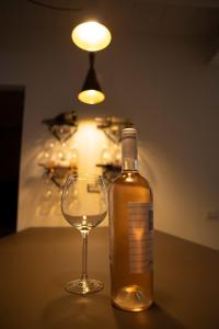 een fles alcohol naast een wijnglas bij House Room Civico 56 in Crotone