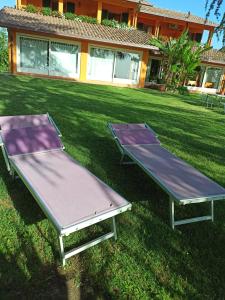 due tavoli da ping pong sull'erba di fronte a una casa di Agriturismo La Quiete a Roncofreddo