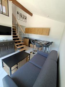 een woonkamer met een bank, tafels en trappen bij Pavillon avec terrasse 6 personnes, piscine, 700m Plage 6EV2PAV425 in Saint Pierre La Mer