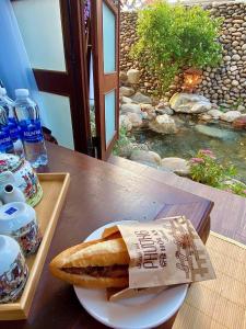 a plate with a piece of bread on a table at Zen House Hoi An - Wooden House in Hoi An