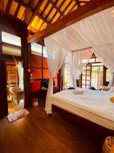 a bedroom with a large bed with white mosquito nets at Zen House Hoi An - Wooden House in Hoi An