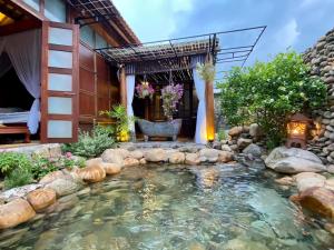 a koi pond in the backyard of a house at Zen House Hoi An - Wooden House in Hoi An