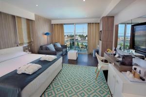 a hotel room with a large bed and a living room at Nestor Hotel in Ayia Napa