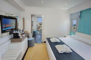 a bedroom with a large bed and a flat screen tv at Nestor Hotel in Ayia Napa