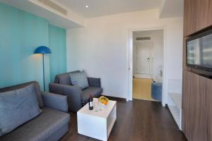 a living room with a couch and a tv at Nestor Hotel in Ayia Napa