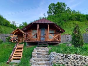 a log cabin in a yard with a fence at VIP-Domyk in Rakhiv
