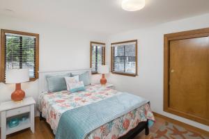 a bedroom with a bed and two lamps and windows at Calle Paradise in Stinson Beach