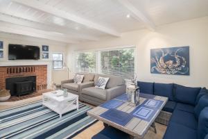 a living room with blue couches and a fireplace at Calle Paradise in Stinson Beach