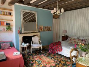 a bedroom with a bed and a fireplace and a mirror at Maison Léontine in Bernay