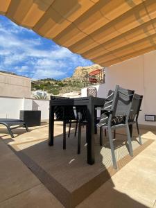 una mesa y sillas en un patio con vistas en Apartamentos Cisneros en Alicante