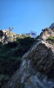una casa sul fianco di una collina con una montagna di Sueño LUXURY VILLA ad Argásion