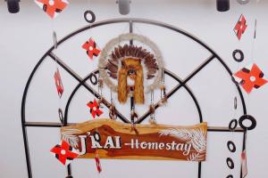 a sign hanging from a metal home stay sign at Jrai Homestay in Pleiku