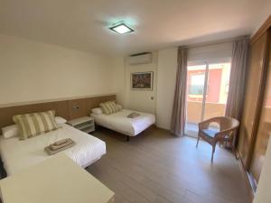 pokój hotelowy z dwoma łóżkami i kanapą w obiekcie Albamar frontline Beach apartment 3 bedrooms w mieście Fuengirola