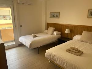 pokój hotelowy z dwoma łóżkami i oknem w obiekcie Albamar frontline Beach apartment 3 bedrooms w mieście Fuengirola