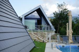 a house with a large window next to a pool at As Cabanas dos Netinhos in Eirado