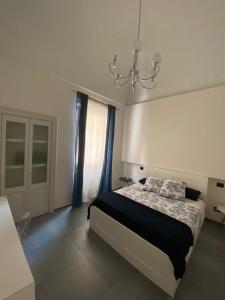 a bedroom with a bed and a chandelier at Appartamento Negroamaro in Galatina