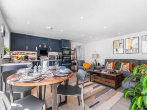 eine Küche und ein Wohnzimmer mit einem Tisch und einem Sofa in der Unterkunft The Apartment at Solley Farm House in Deal
