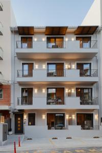 レティムノ・タウンにある7 City Luxury Apartmentsのバルコニー付きのアパートメントビルディング