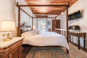 a bedroom with a bed and a desk and a television at Hotel La Casa de las Sirenas in Tlacotalpan