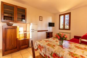 a kitchen with a table and a refrigerator at Agriturismo La Banchella in Scarlino