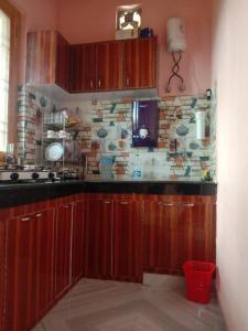 a kitchen with wooden cabinets and a stone wall at Odyssey Stays Majkhali, Ranikhet in Chaubattia