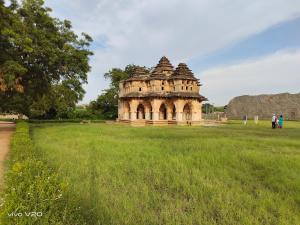 a building in the middle of a field at Srinivasa Homestay in Hampi