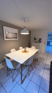 Apartment near Europa-Park & Black Forest في كابل غرافنهاوسن: غرفة طعام مع طاولة بيضاء وكراسي